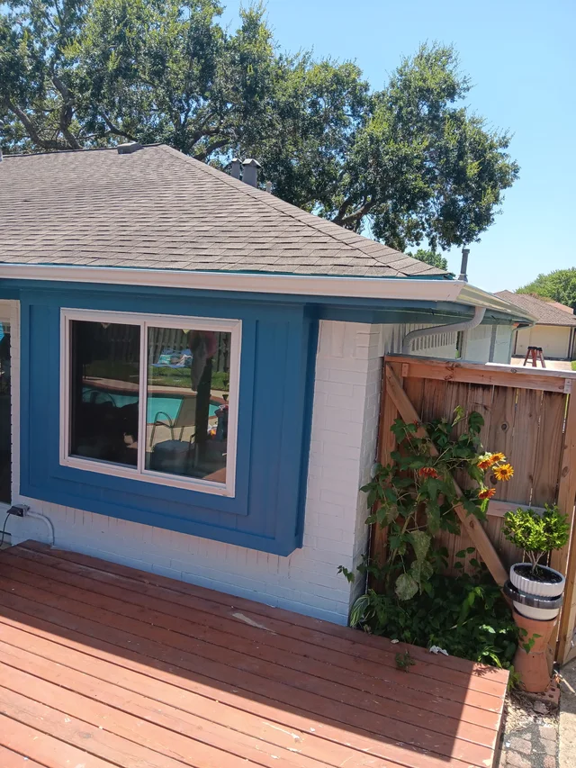 White gutters and downspouts against blue-gray siding